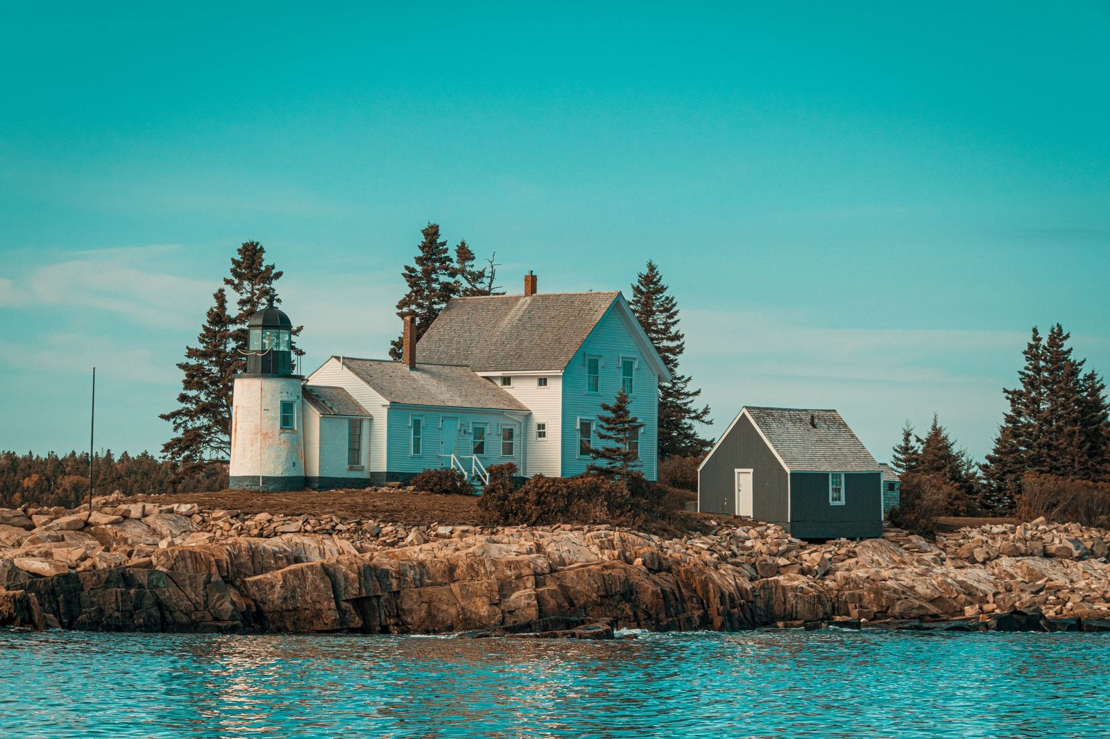 Scenic view of a coastal lighthouse and house on rocky shores in Maine, USA. Ideal for travel inspiration