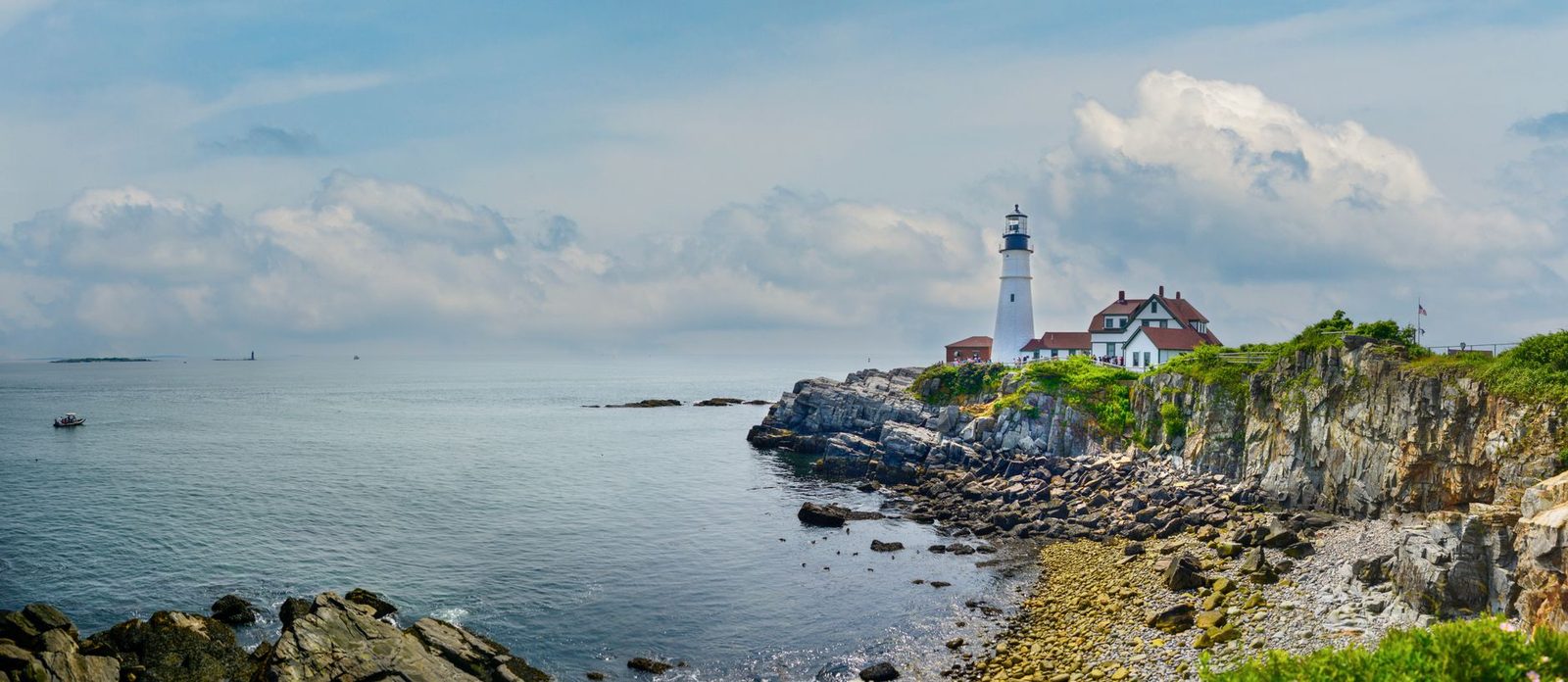 Panoramic view of Portland Head Light on Maine's rugged coastline under a clear sky